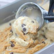 Close up of an ice cream scoop scooping peanut butter chocolate chip ice cream.