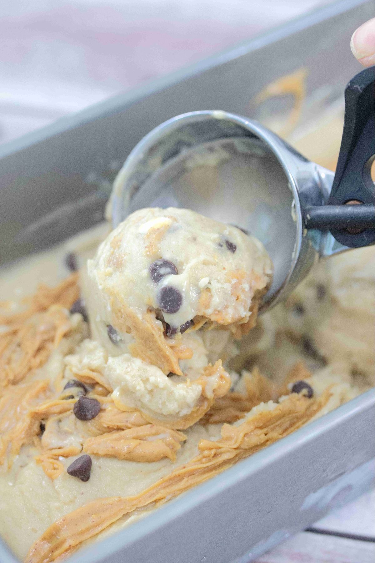 Close up of an ice cream scoop scooping peanut butter chocolate chip ice cream