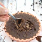 Chocolate baked protein oats in a silicone mold with a spoon in it.