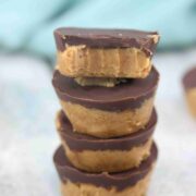 Four chocolate peanut butter cups stacked together with the last one with a bite out of it on top