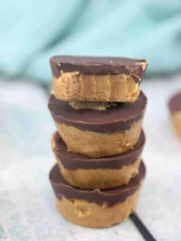 Four chocolate peanut butter protein cups stacked.