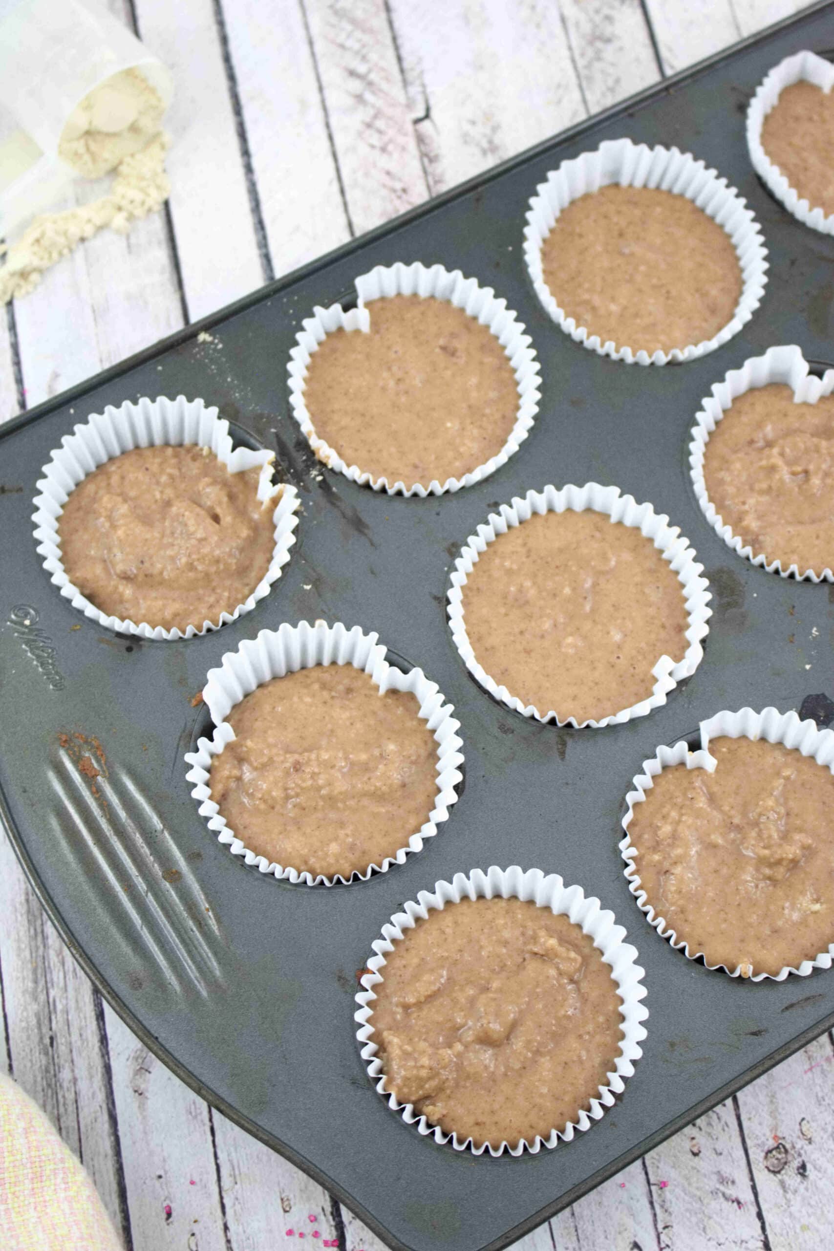Muffin tin with raw chocolate protein muffin batter.