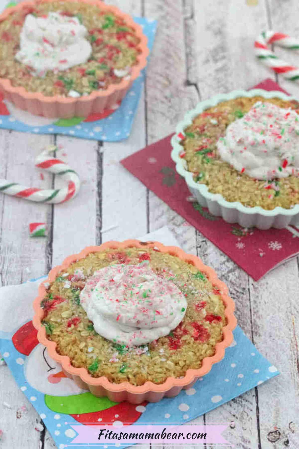 Candy cane baked oatmeal with coconut whipped cream in a orange mold on a blue napkin and more oatmeal and candy canes around it.