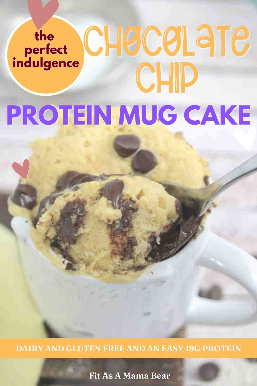 white mug with chocolate chip mug cake in it with a spoon on a wooden cutting board and text on the image.