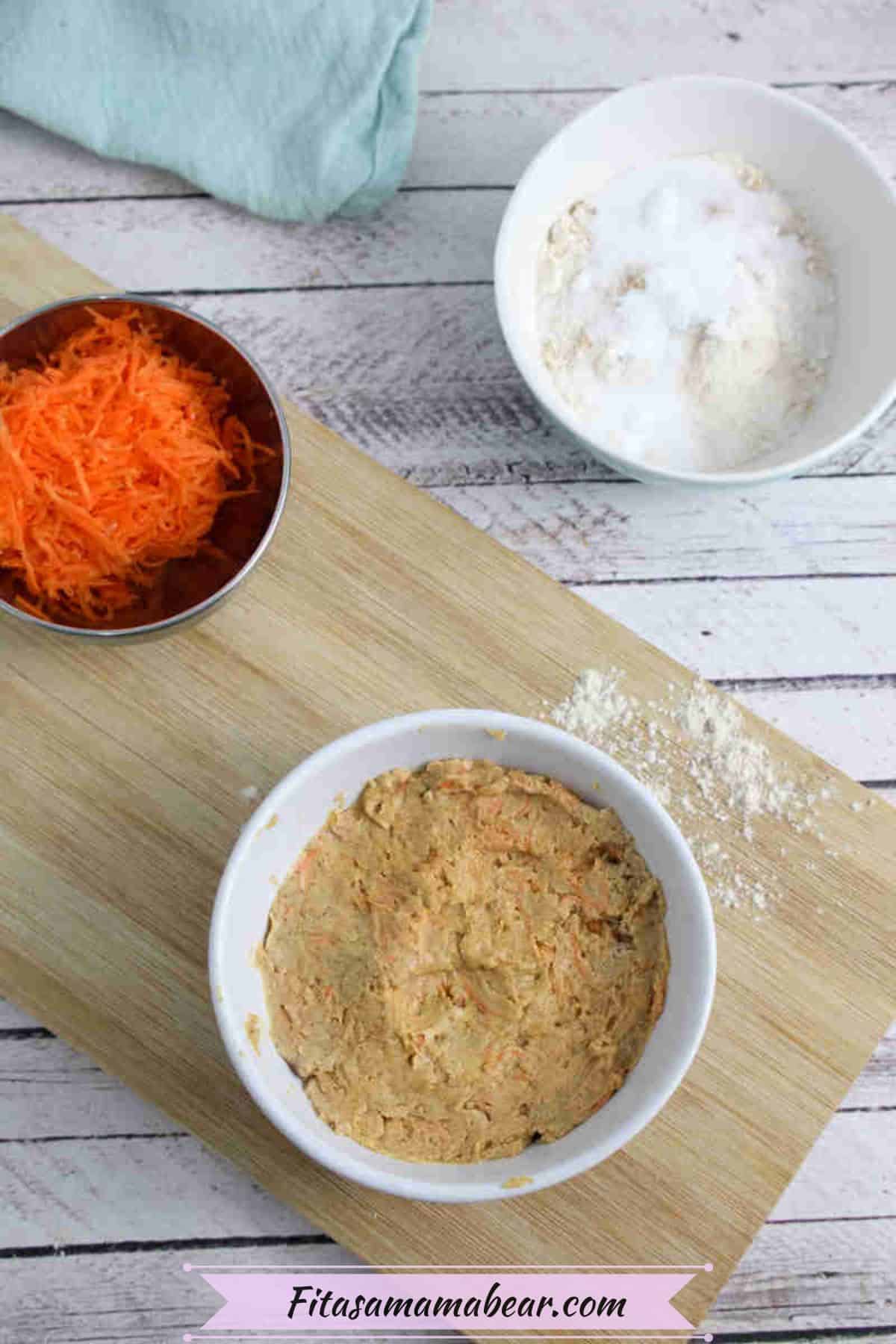 White ramekin with carrot mug cake batter on a wooden cutting board with grated carrot behind it.