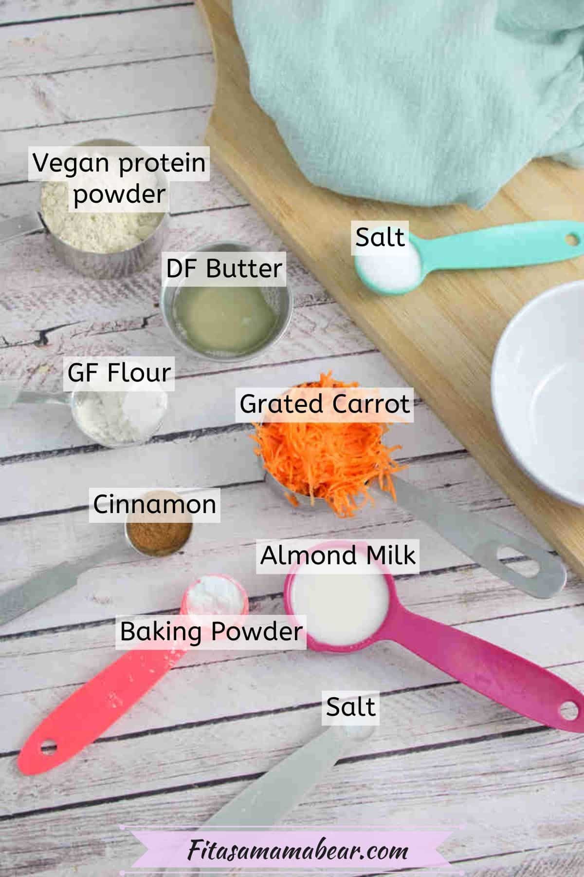 Ingredients to make carrot cake mug cake in measuring cups with text labels over top.