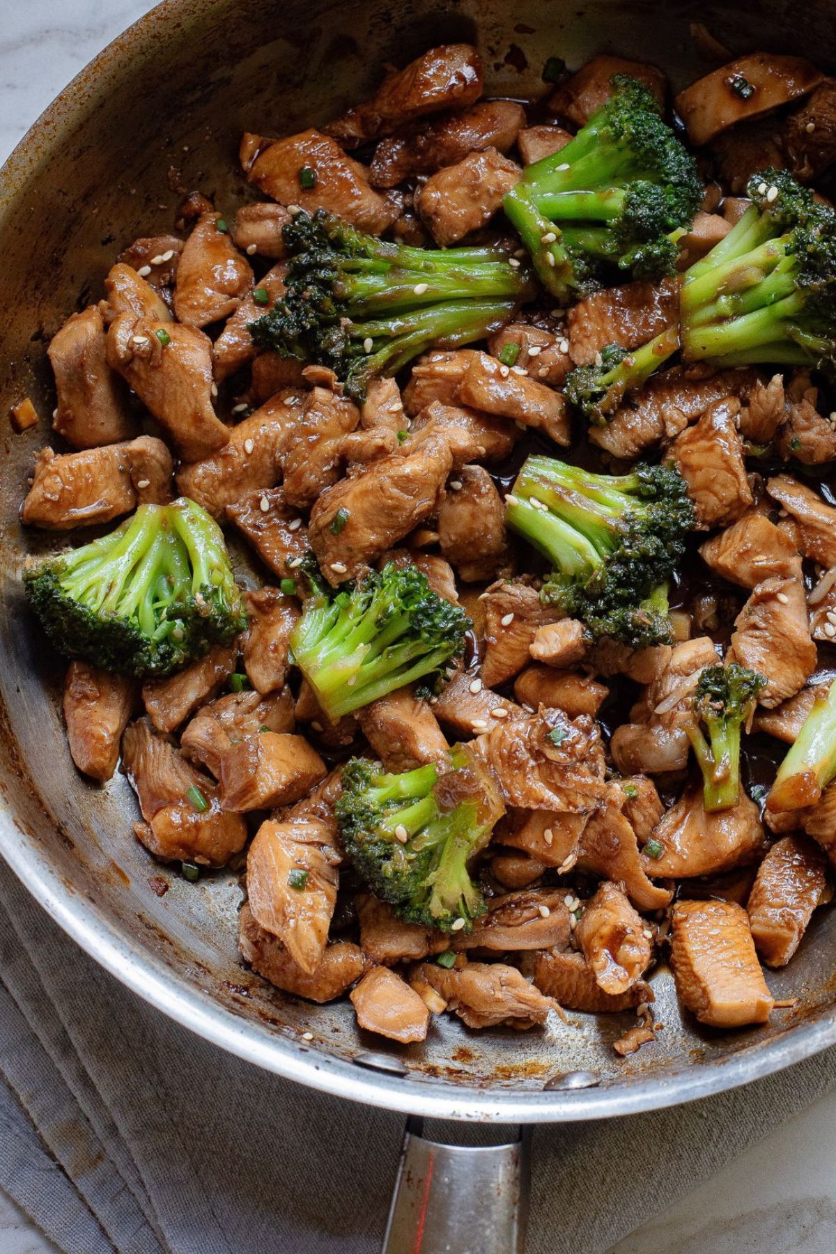 Skillet with teriyaki chicken and broccoli in it.
