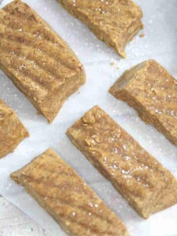 No bake gingerbread protein bars in lines on parchment paper.