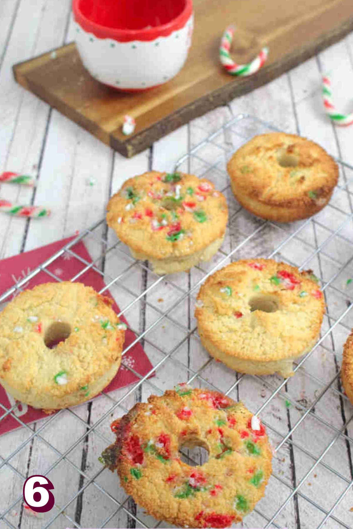 Candy cane donuts on a cooling rack.