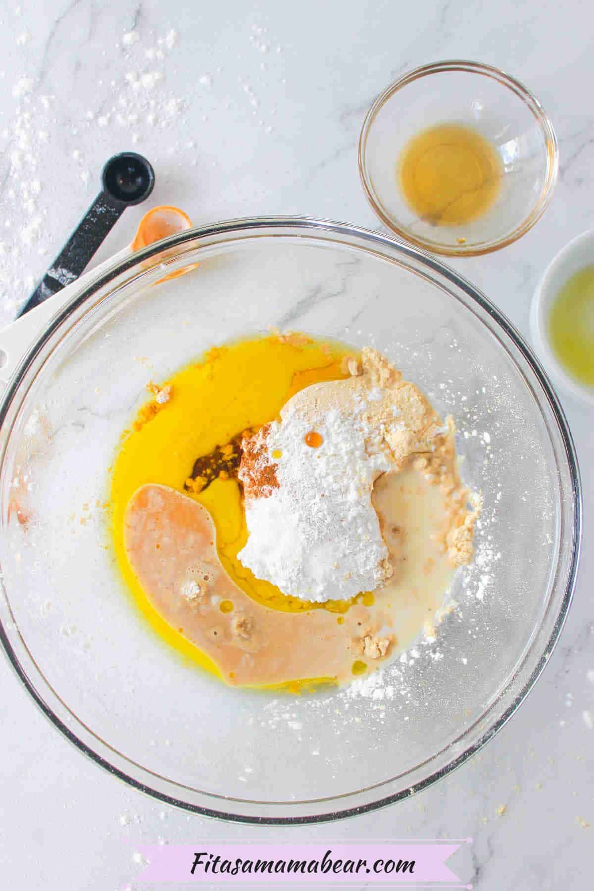 Protein powder, oil, and maple syrup in a glass bowl.