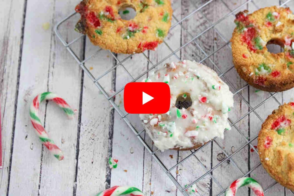 Candy cane donuts with white icing on a cooling rack with a red arrow over top.