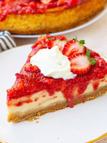 Protein cheesecake topped with strawberries topping on a white plate.