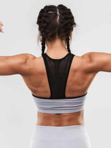 View of womans back while she is flexing her arms.