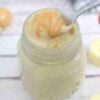 Banana protein pudding in a jar with peanut butter on top and a spoon in the jar.