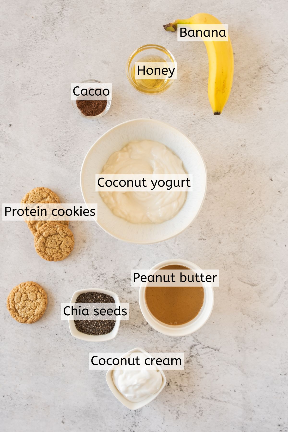 Multiple ingredients to make a chia pudding breakfast parfait with text labels over the ingredients.