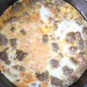Cooked beef and scrambled eggs in a black skillet.