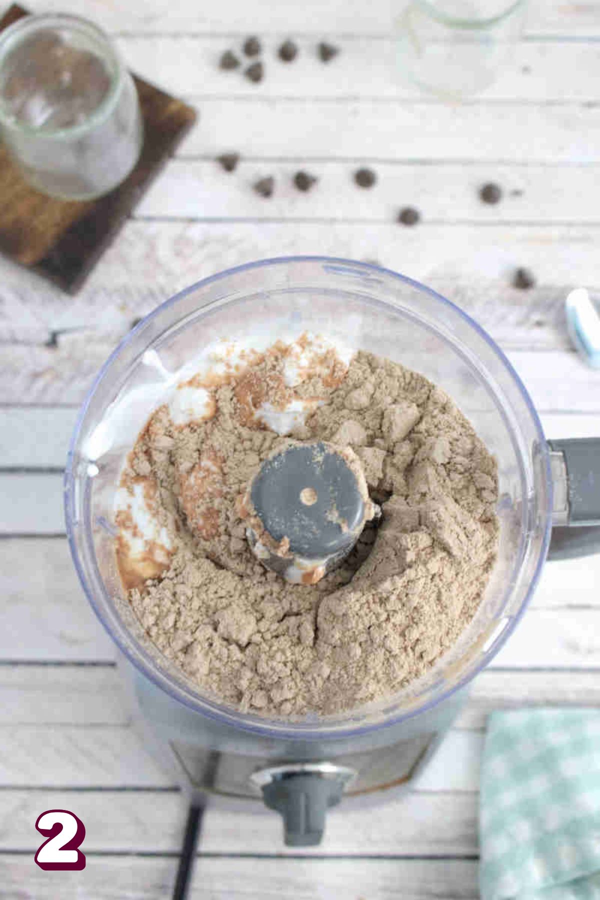Mini blender with protein powder, coconut cream in it.