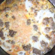 Cooked beef and scrambled eggs in a black skillet.