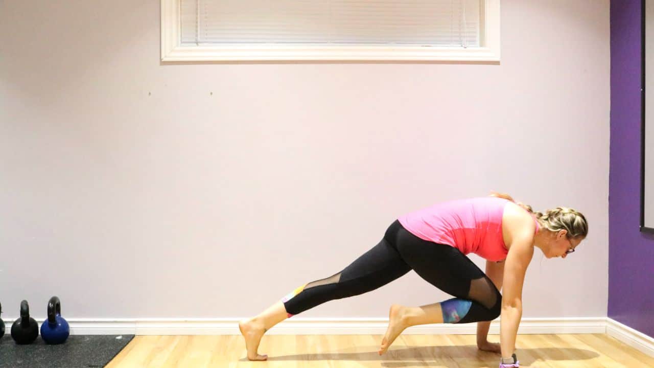 Woman performing a mountain climber exercise on the ground.