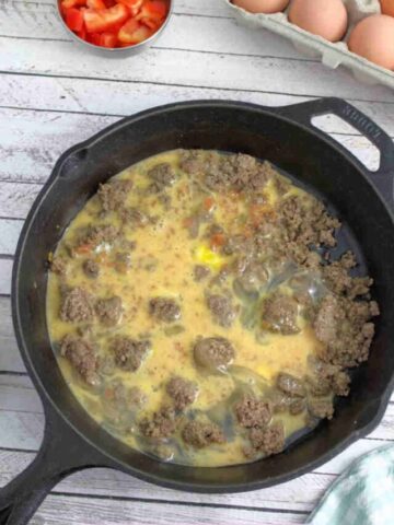 Beef and scrambled eggs in a black skillet