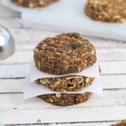 Three no bake protein cookies stacked with parchment paper between them.