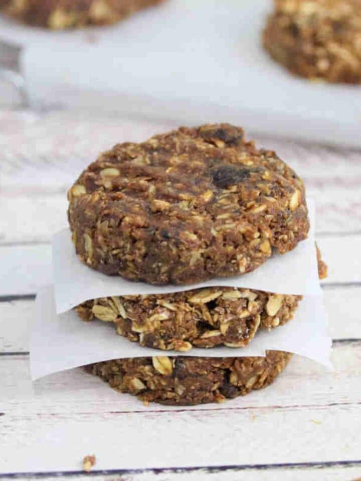Three no bake protein cookies stacked with parchment paper between them.