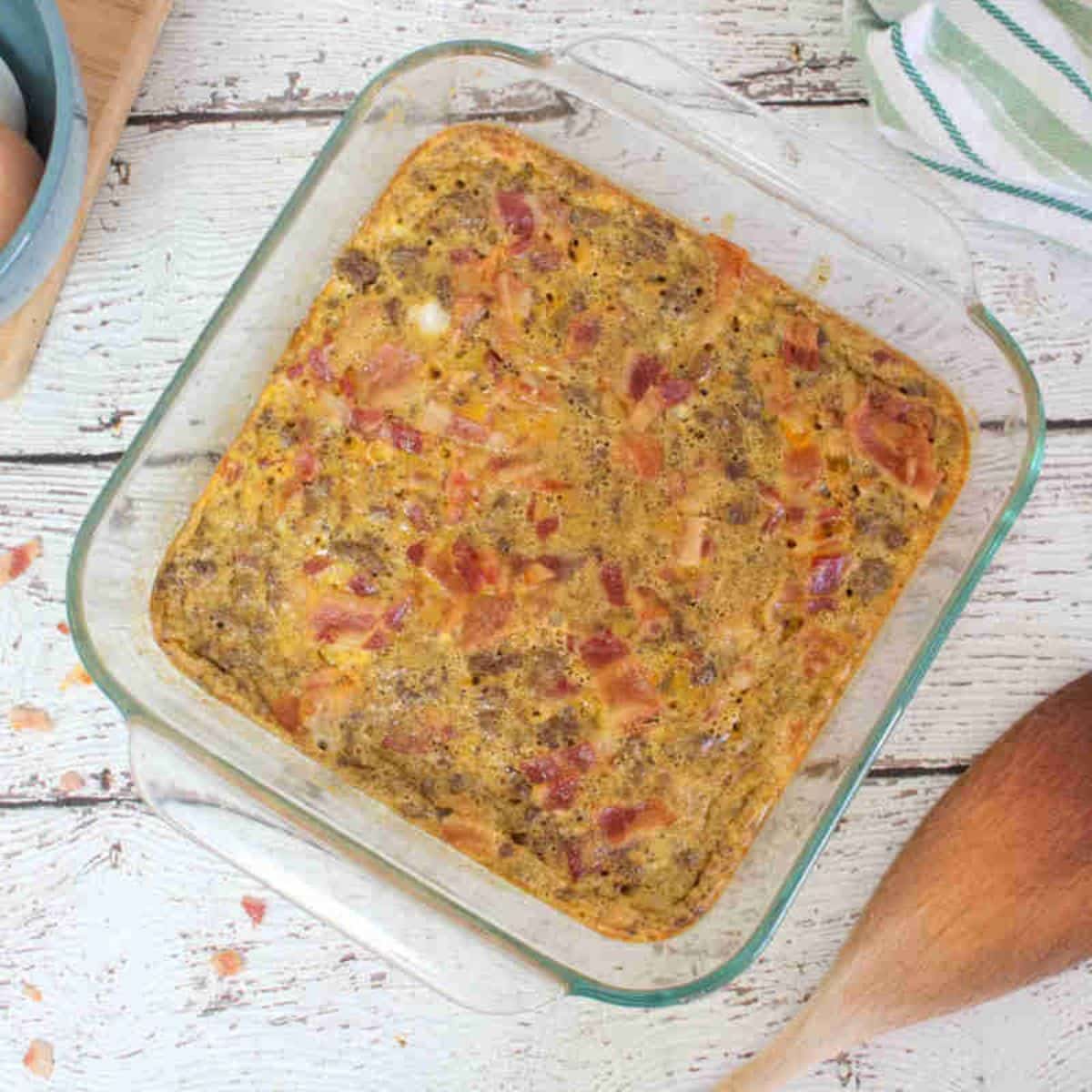 Carnivore casserole topped with bacon in a glass serving dish.