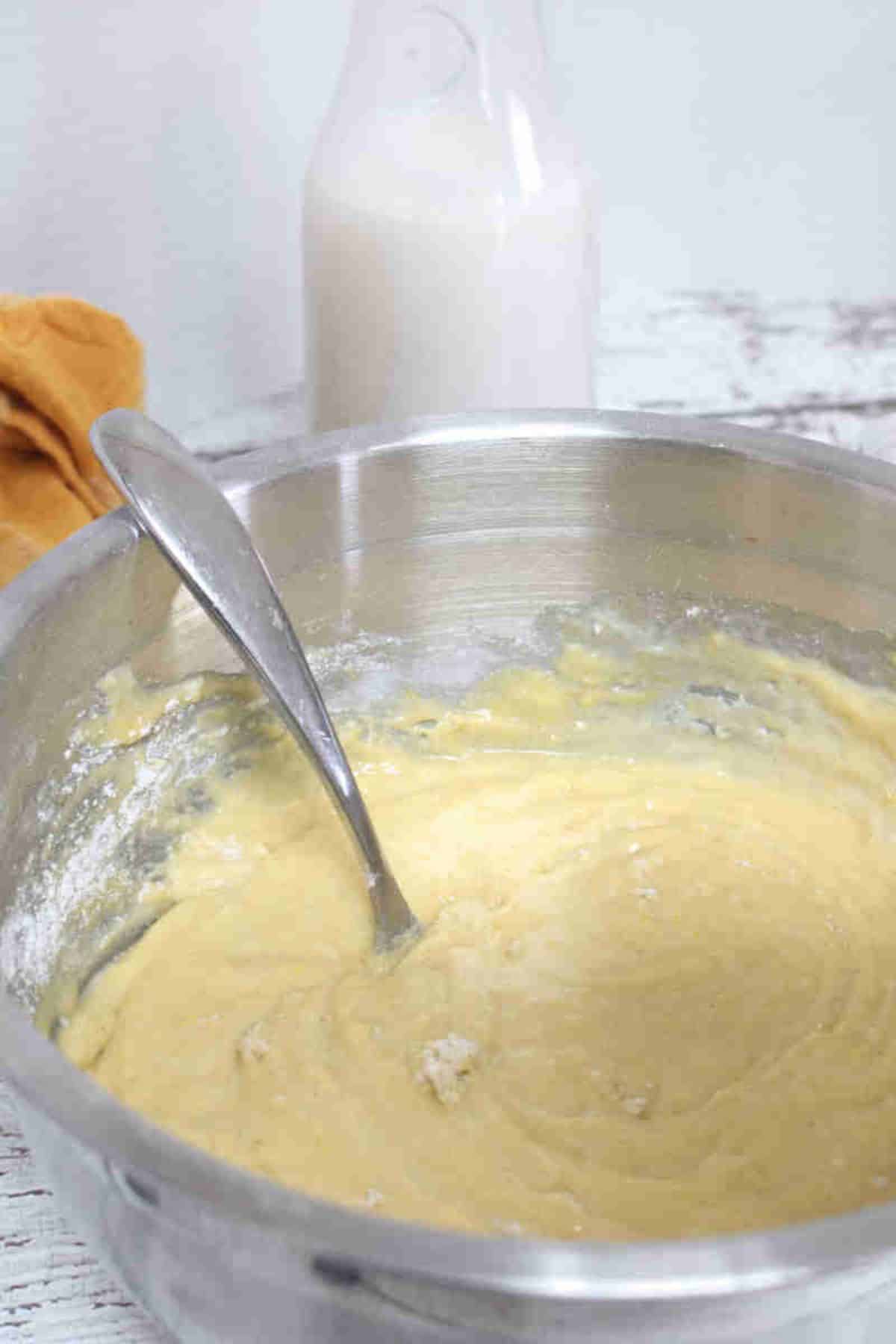 Steel bowl with raw pancake batter and a fork.