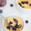 Baked yogurt with blueberries in a bowl with a spoon.