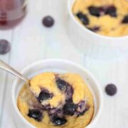 Baked yogurt with blueberries in a bowl with a spoon.