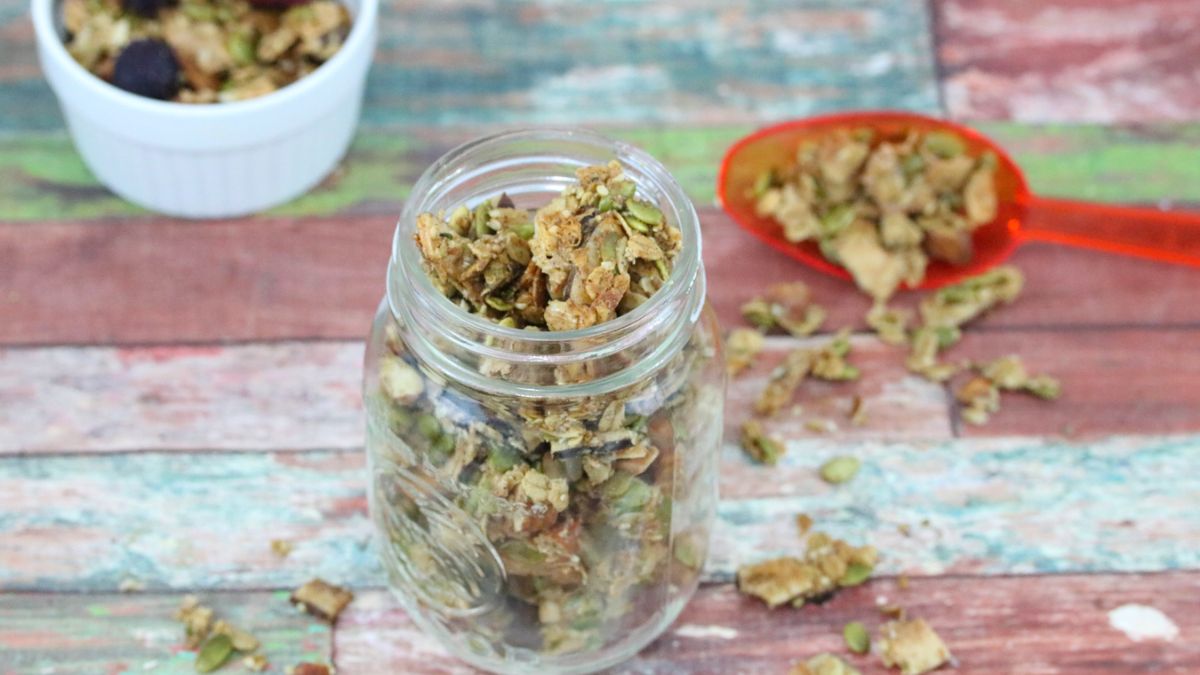 Mason jar full of granola with more around it.