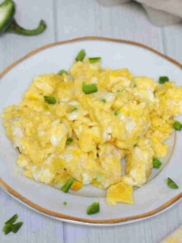 Scrambled eggs with jalapenos on a plate.