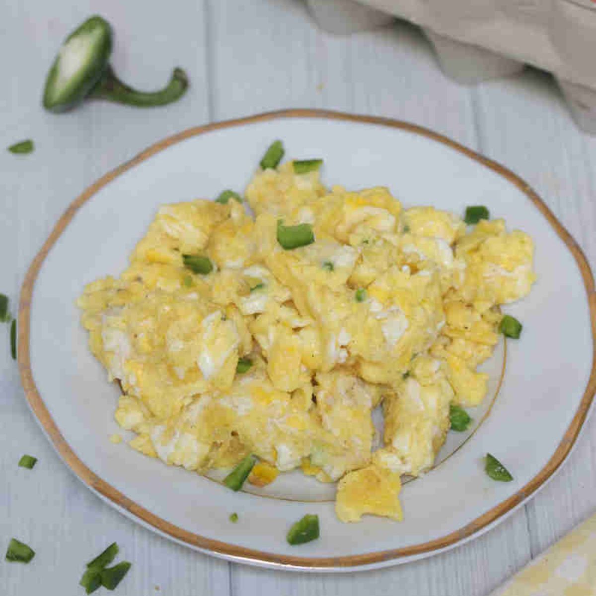 Scrambled eggs with jalapenos on a plate.