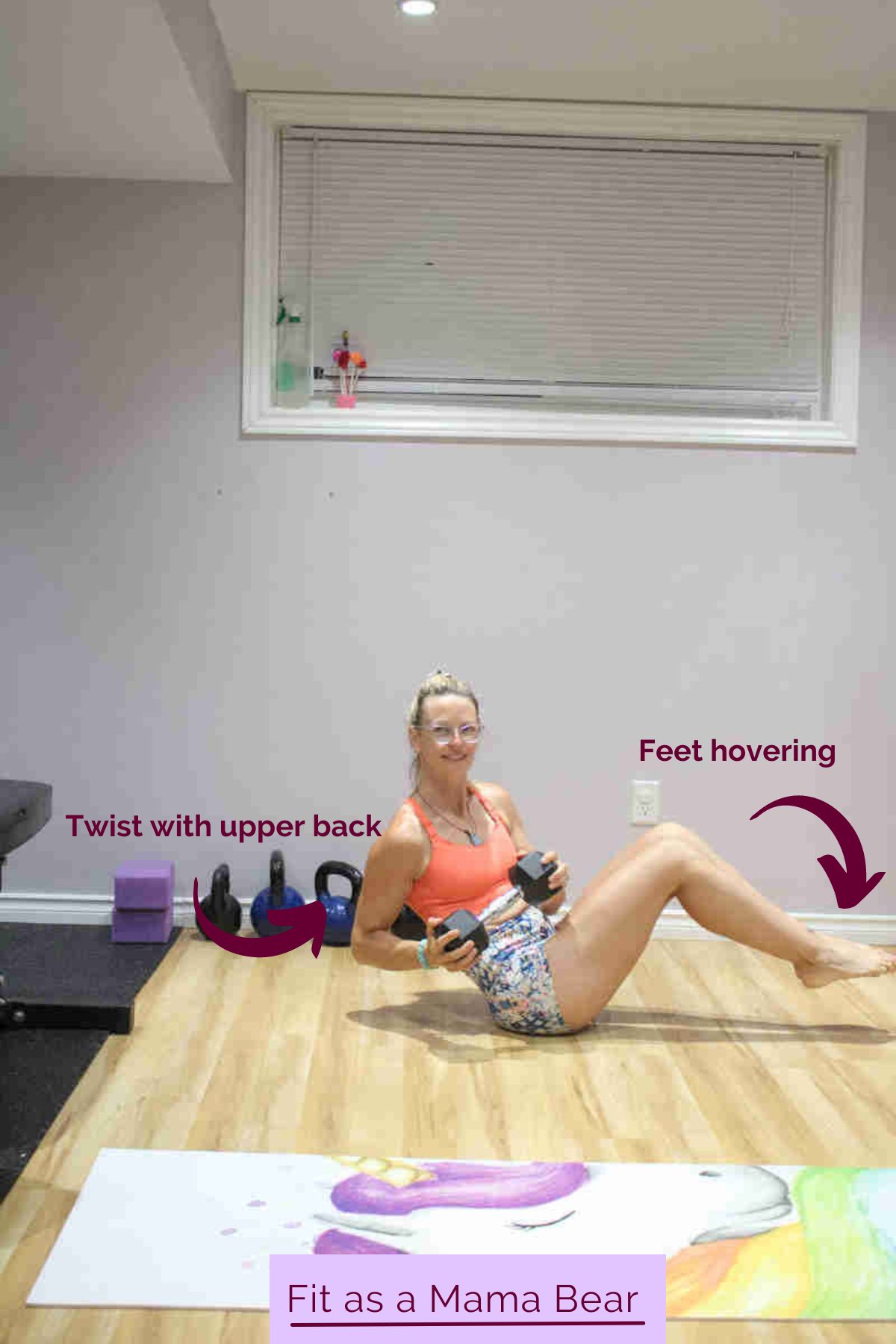 Woman in orange sports bra and shorts sitting with her legs up on the floor and holding a dumbbell while twisting.