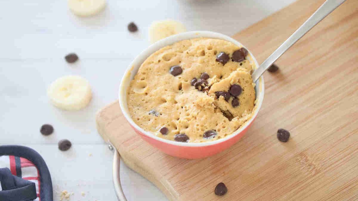 Mug cake with chocolate chips in a ramekin with a spoon in it.