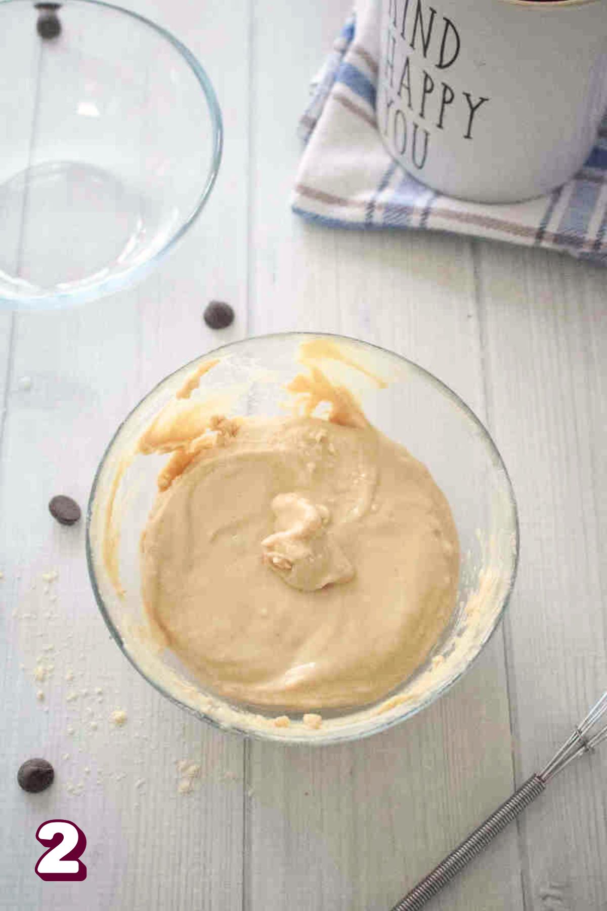 Glass bowl with raw pancake batter in it and another bowl behind it.