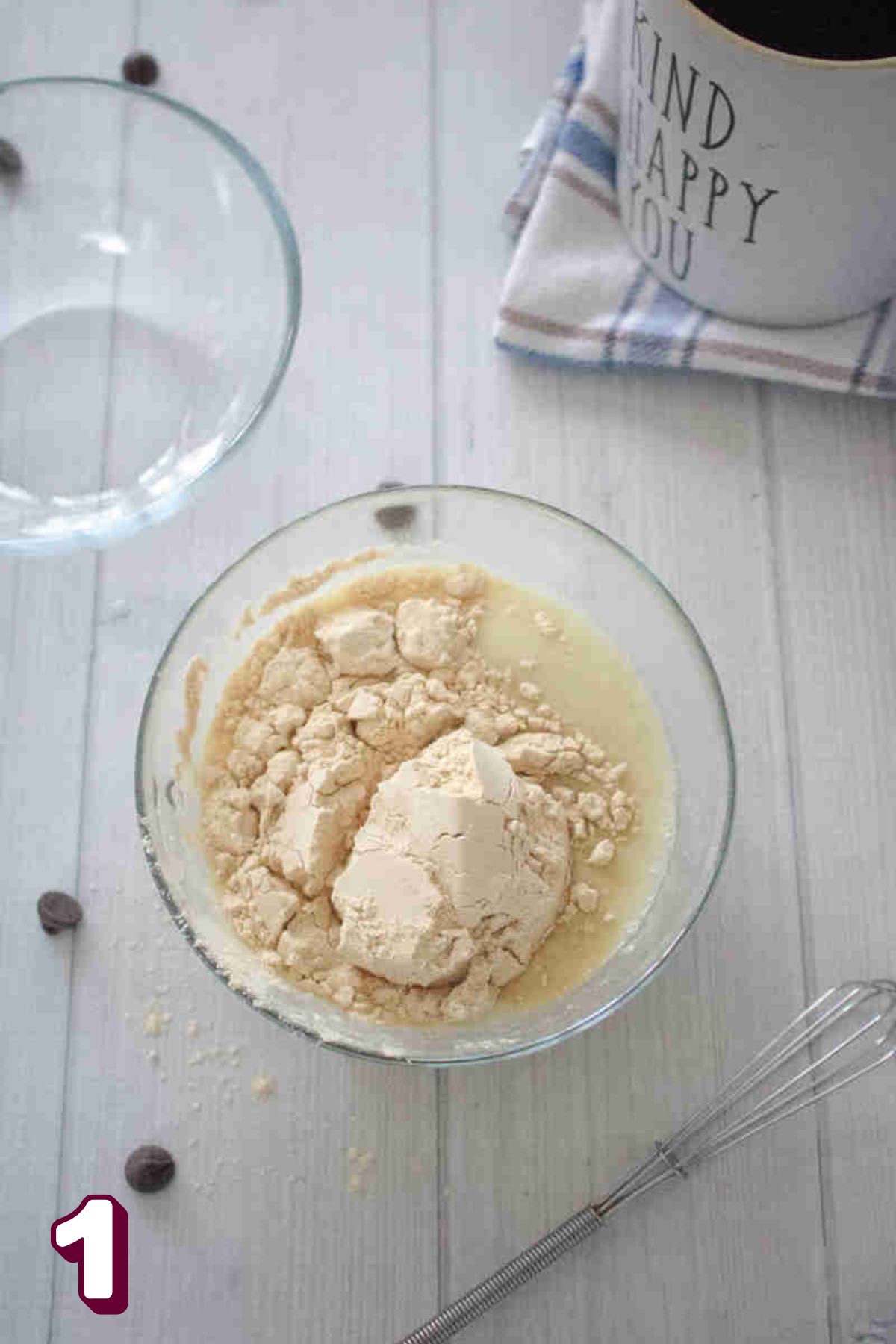 Glass bowl with egg whites and protein powder in it and another bowl behind it.