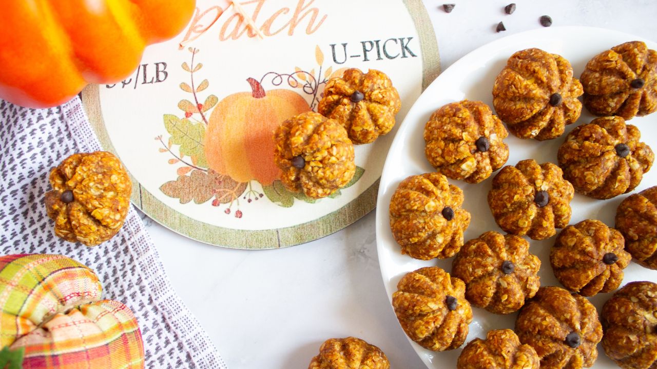 Pumpkin energy balls on a plate with more on a fall back drop.