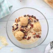 A bowl of cookie dough smoothie bowl topped with chocolate chips and pecan nuts.