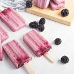 Black berry popsicle sticks with black berries spread around them.
