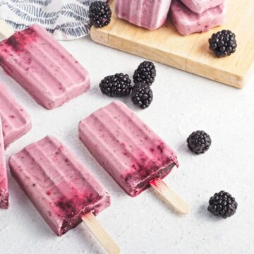 Black berry popsicle sticks with black berries spread around them.
