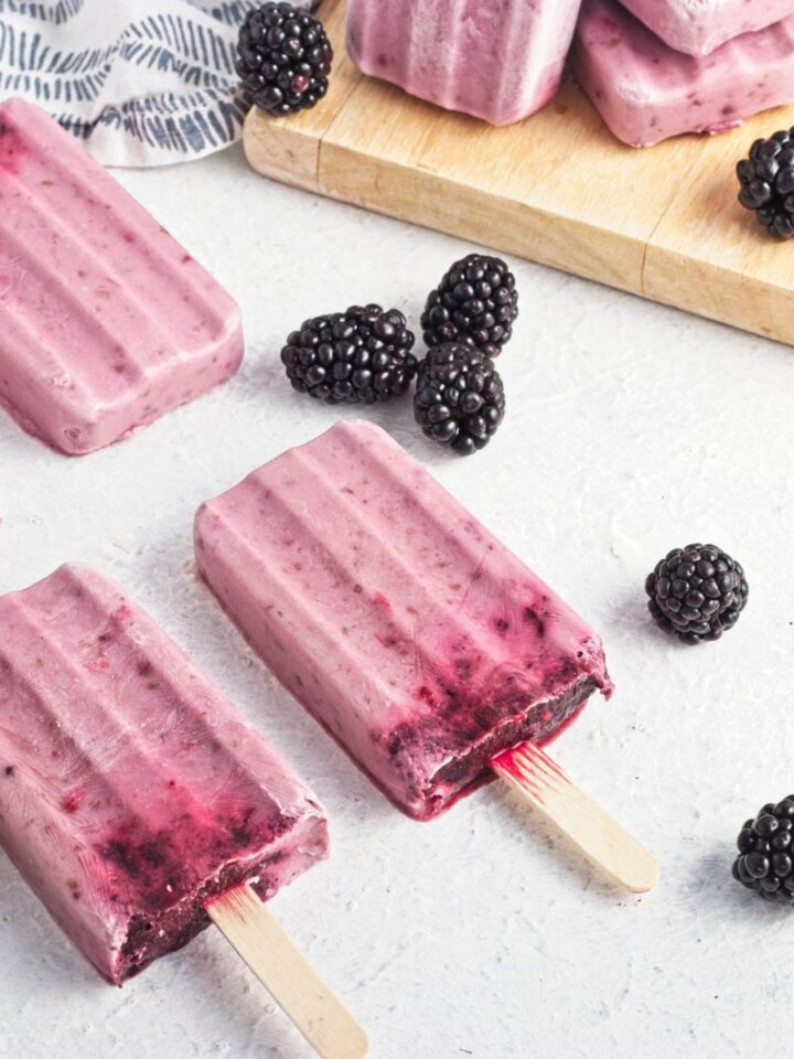 Black berry popsicle sticks with black berries spread around them.