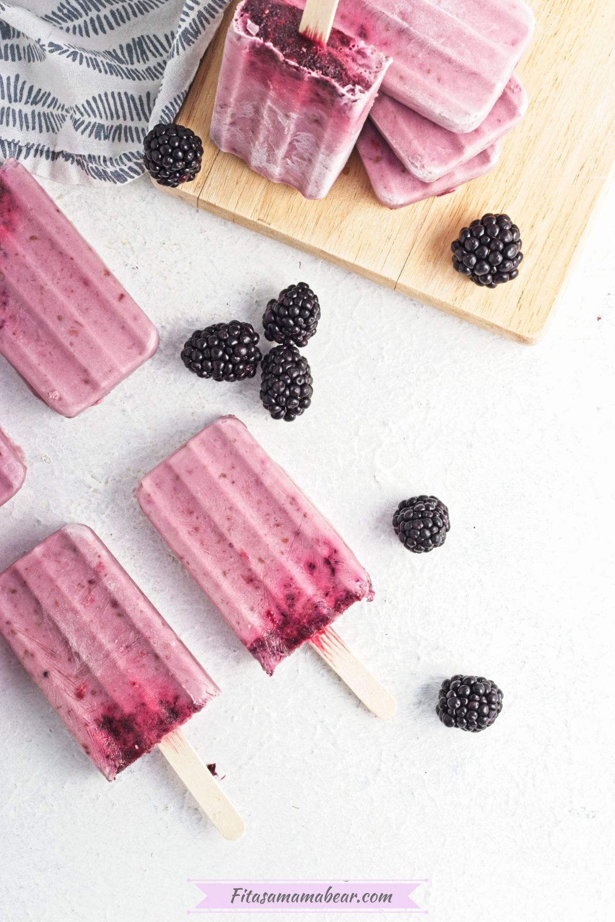 frozen black berry popsicles with blackberries around