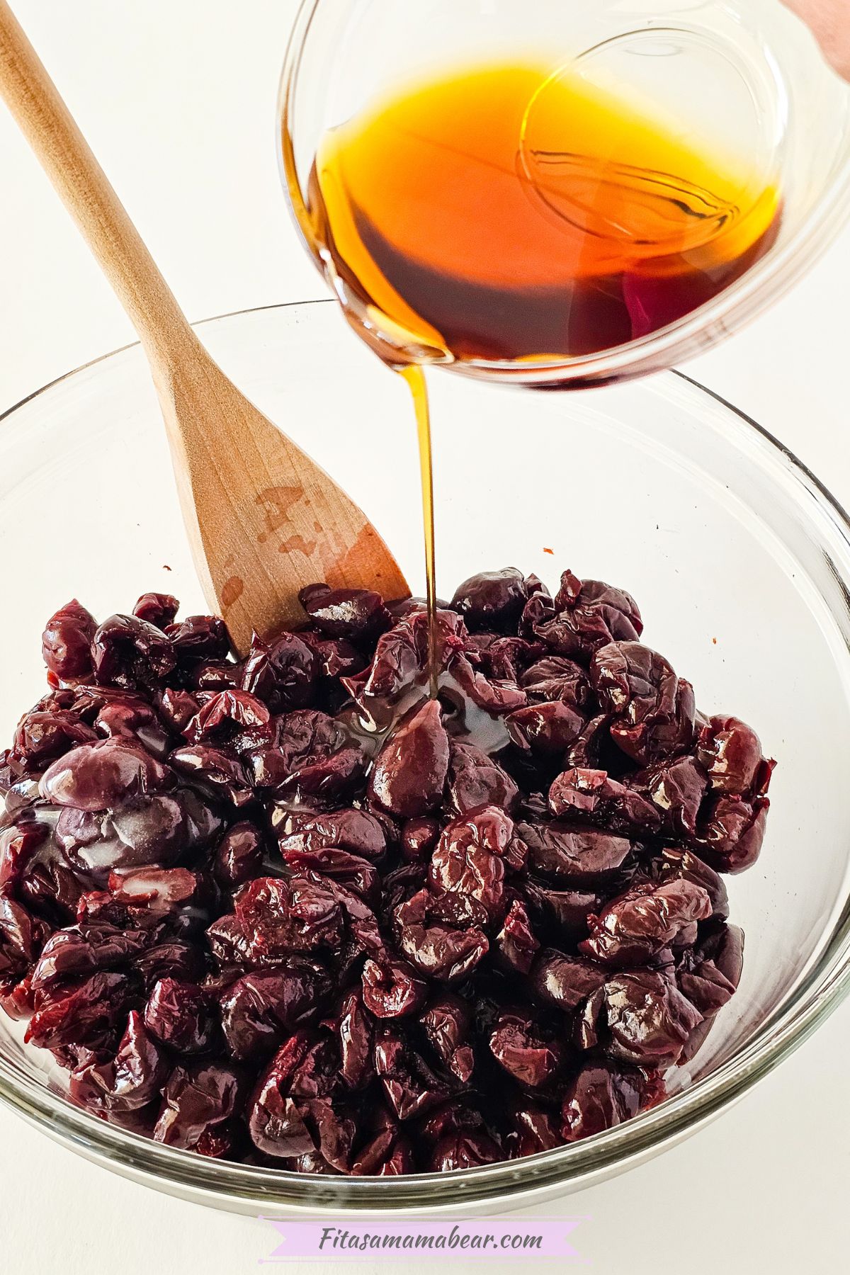 a bowl of cherries mixed with maple syrup, non dairy buttern, and almond extract