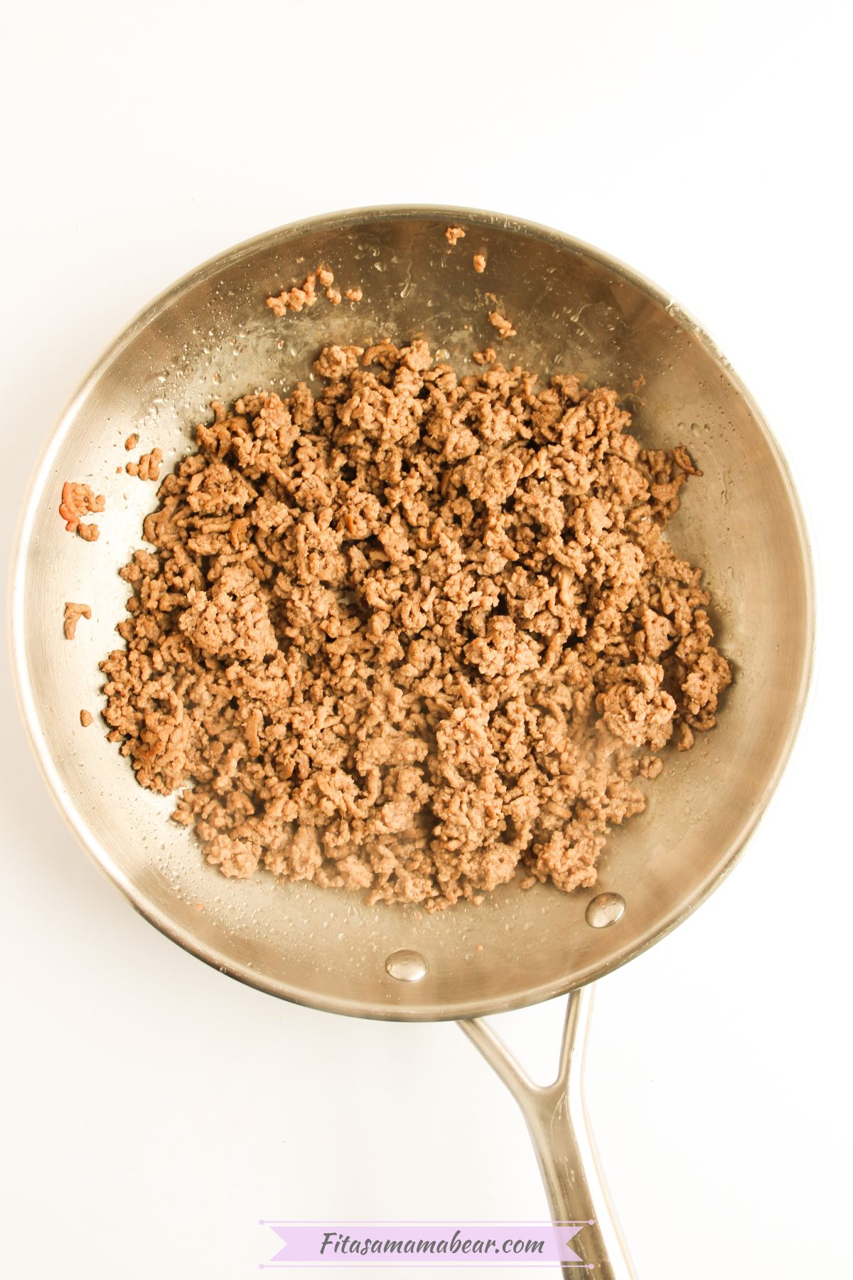 Ground beef cooked in a stainless steel skillet.