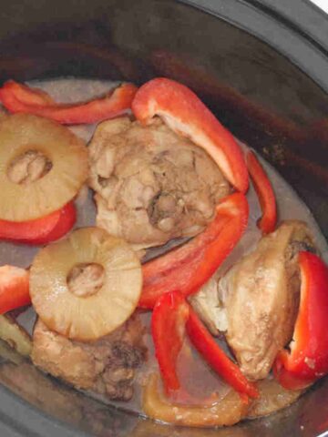 Slow cooker Hawaiian chicken with peppers and pineapples in a crockpot.