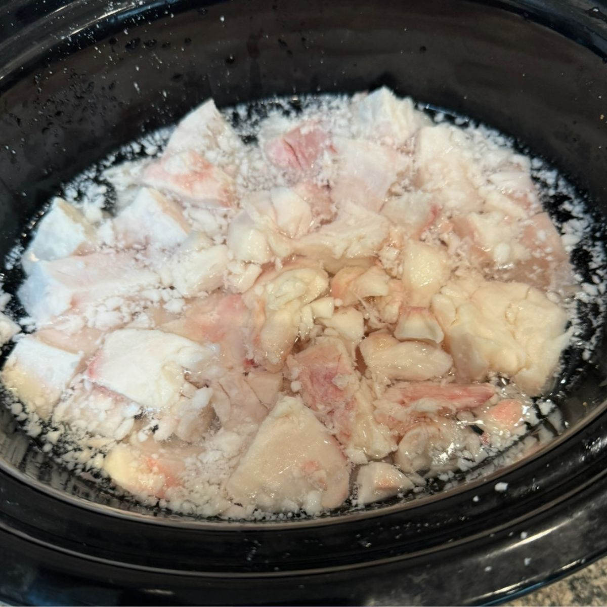 Beef tallow boiling in a slow cooker.