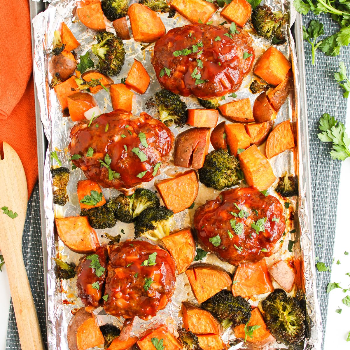 Mini meatloaves with barbecue sauce and vegetables roasted in a sheet pan.