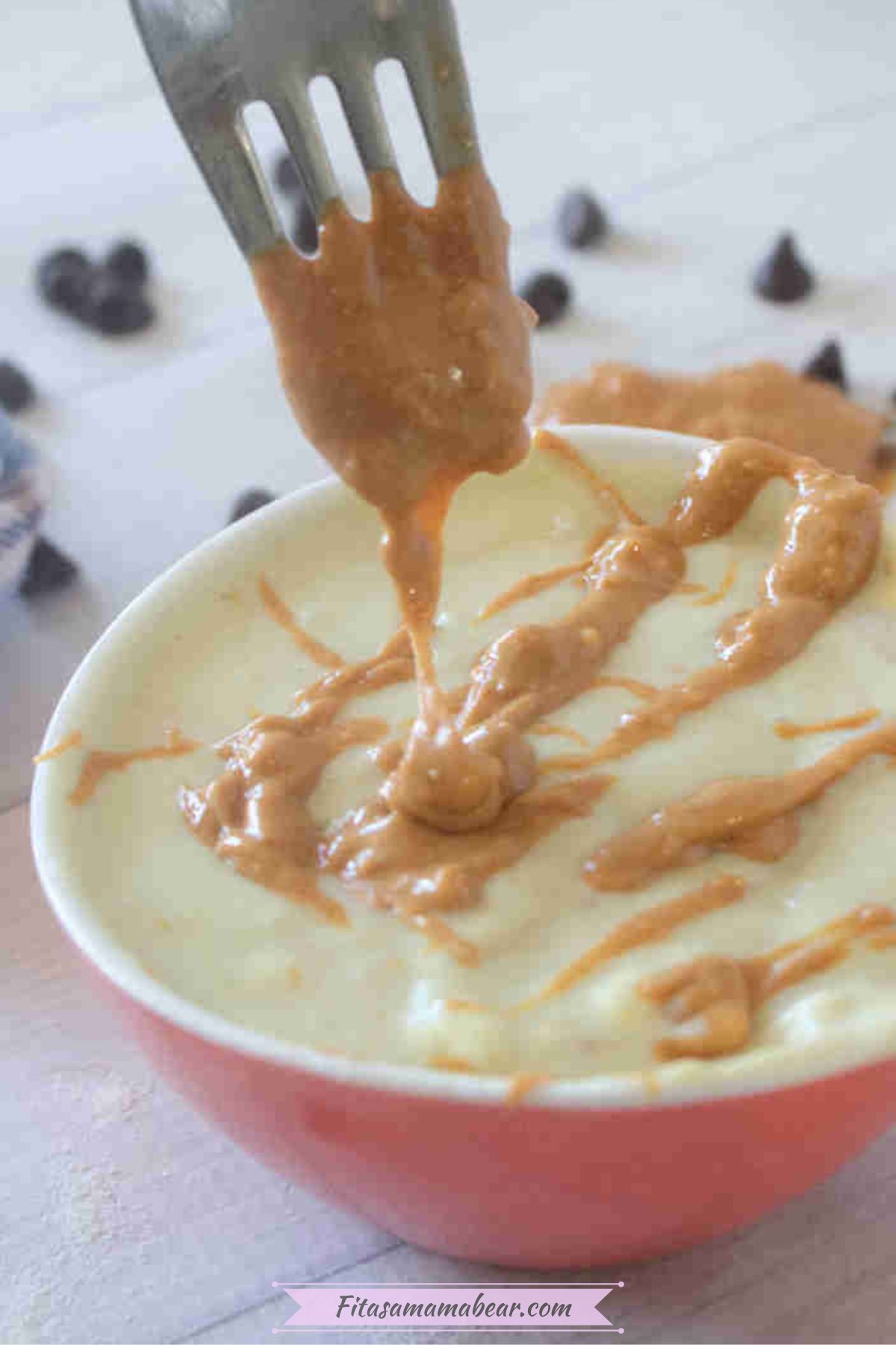Greek yogurt pudding in a bowl topped with peanut butter swirls.