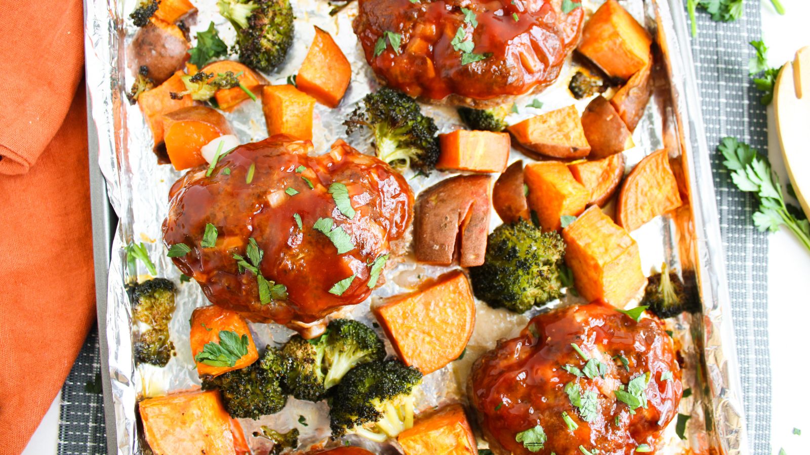 Sheet pan barbecue meat loaves with roasted broccoli and sweet potatoes.